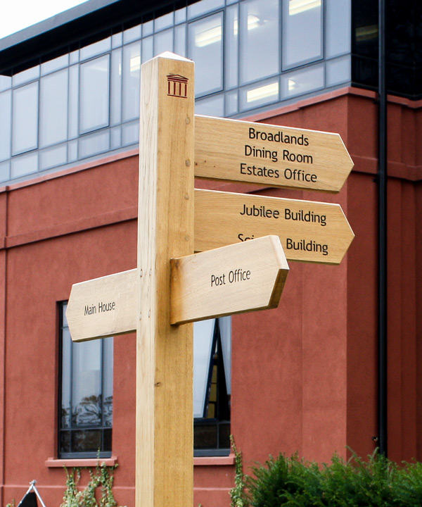 Wooden Fingerpost Sign with wide arms, black infilled lettering and custom post logo. Wooden Fingerpost Sign with wide arms, black infilled lettering and custom post logo.
