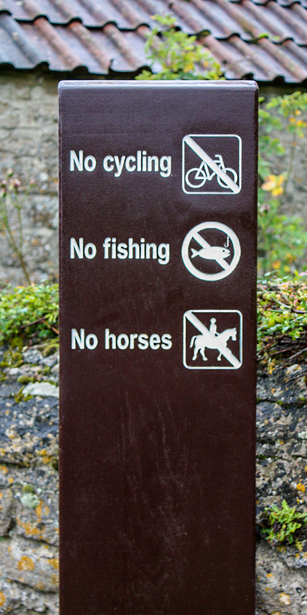 Wooden Monolith Sign with a painted surface finish and warning symbols